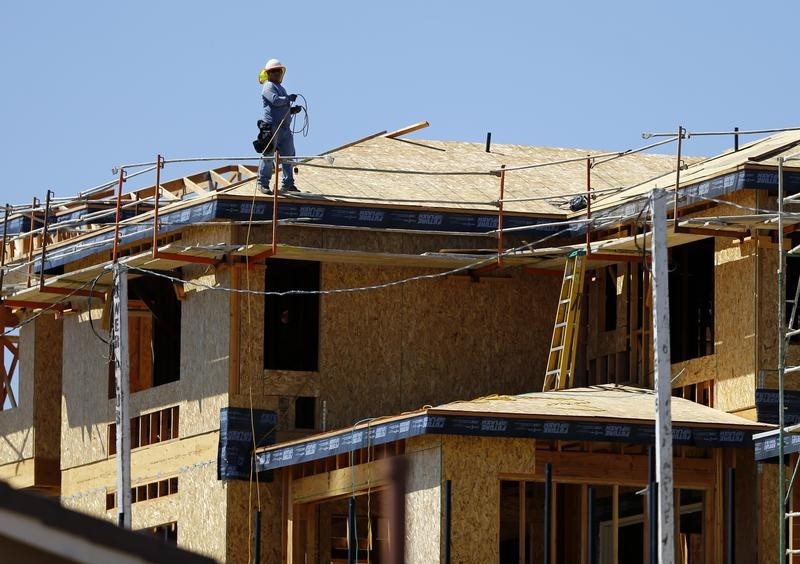 © Reuters. A worker walks on the roof of a new home under construction in Carlsbad