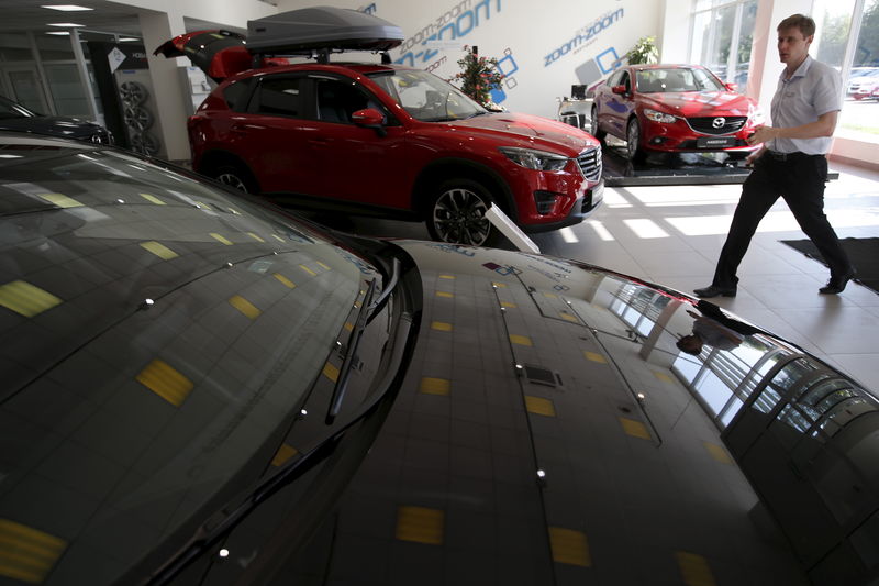 © Reuters. Employee walks past Mazda Motor Co.'s cars at a showroom of Avtomir company in Moscow