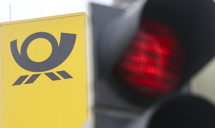 © Reuters. The logo of German mail carrier Deutsche Post is seen next to a red traffic light during a demonstration Munich
