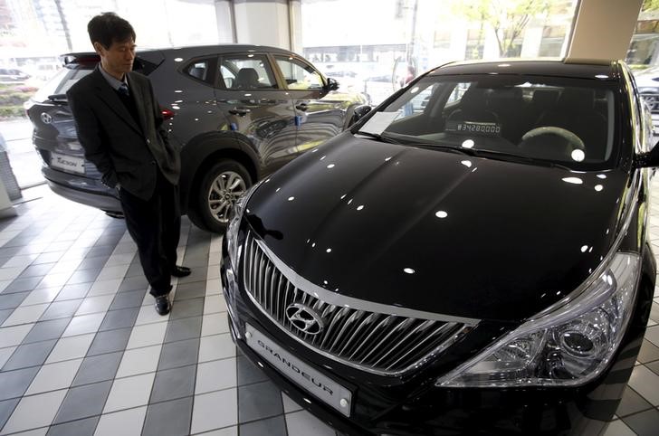© Reuters. A visitor looks at a Hyundai Motor Co's Grandeur sedan at its dealership in Seoul