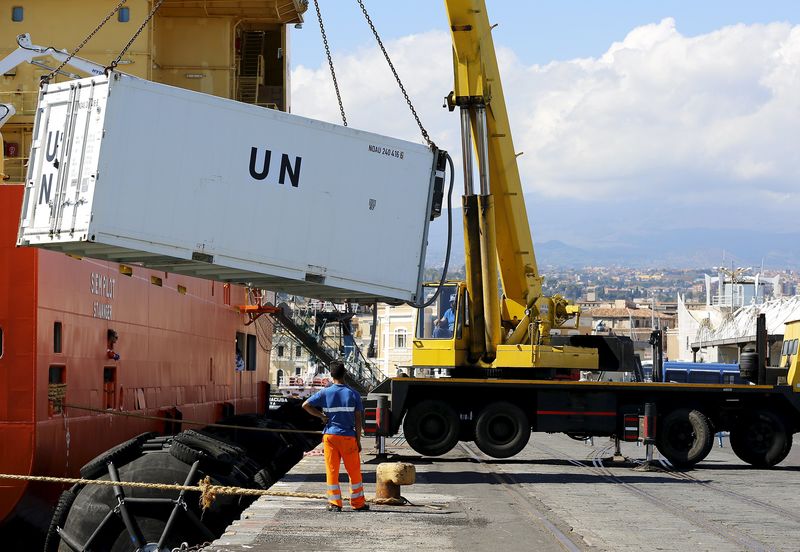 © Reuters. A container, carrying the bodies of 49 migrants, is removed from the Norwegian ship Siem Pilot at the Sicilian harbour of Catania