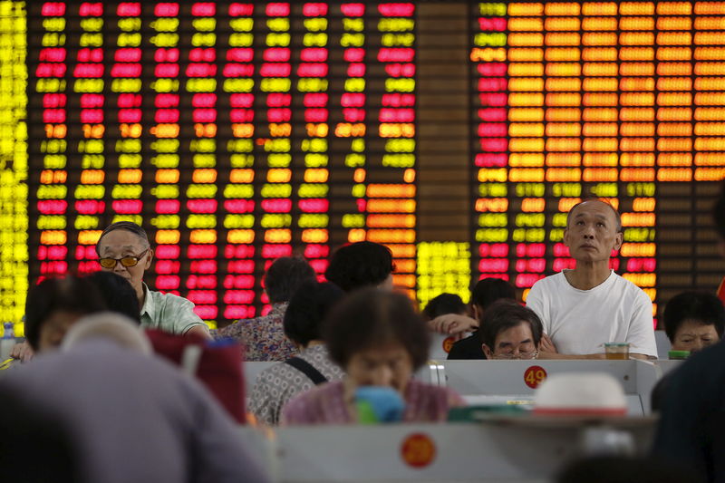 © Reuters. Investors look at computer screens showing stock information at a brokerage in Shanghai
