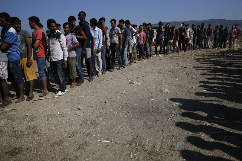 © Reuters. Imigrantes fazem fila para receber lanches em ilha grega