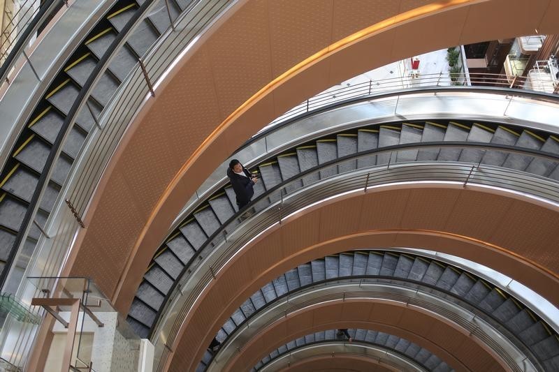 © Reuters. A man rides a spiral elevator in a new shopping mall in Shanghai