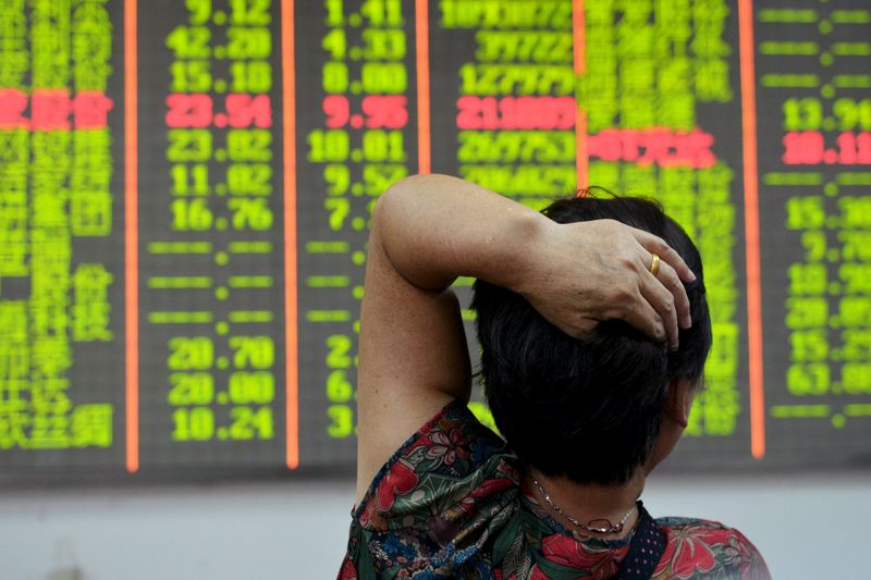 © Reuters. Investor looks at an electronic board showing stock information at a brokerage house in Hangzhou, Zhejiang province, China 