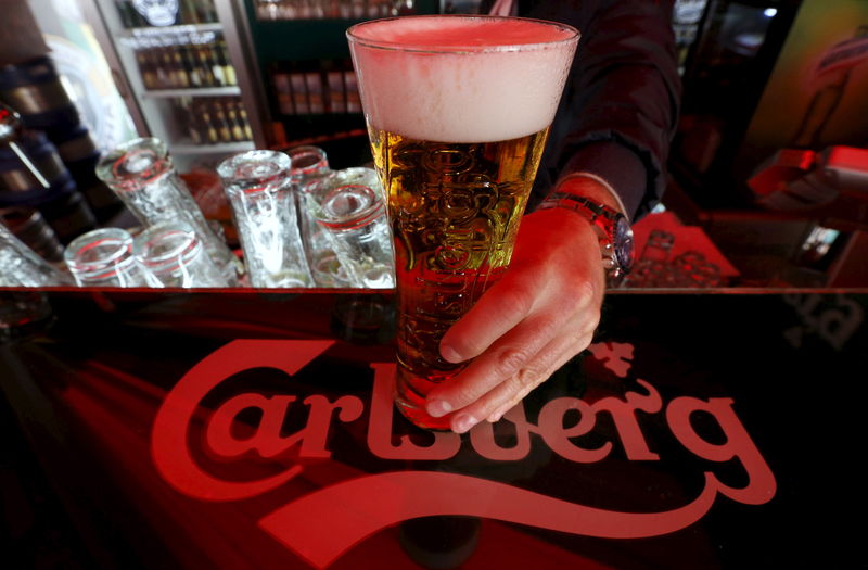 © Reuters. File photo of a bartender holding a glass of Carlsberg beer in a bar in St. Petersburg