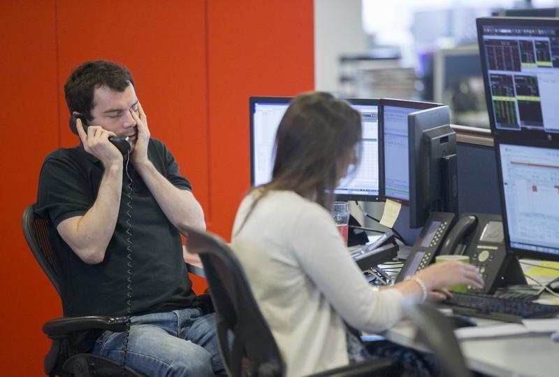 © Reuters. A dealer reacts as he makes a phone call on the IG Group trading floor in London, Britain