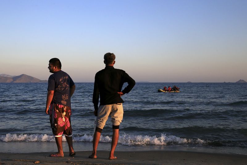 © Reuters. Migrants from Pakistan paddle a dinghy as they cross a part of the Aegean sea from the Turkish coast on the Greek island of Kos