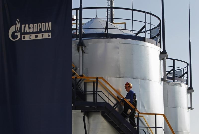 © Reuters. Рабочий НПЗ Газпромнефти поднимается по лестнице 