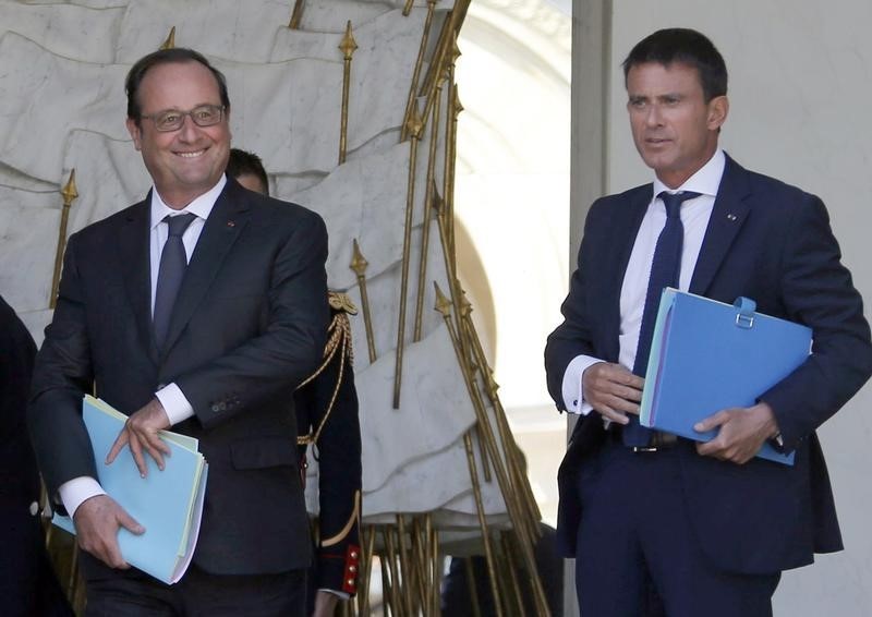 © Reuters. French President Francois Hollande escorts Prime Minister Manuel Valls after the first cabinet meeting following the summer break at the Elysee Palace in Paris