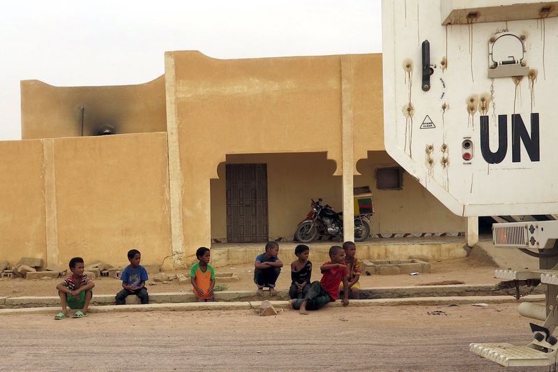 © Reuters. Children watch as a Minusma peacekeeping armored vehicle drive past in Kidal