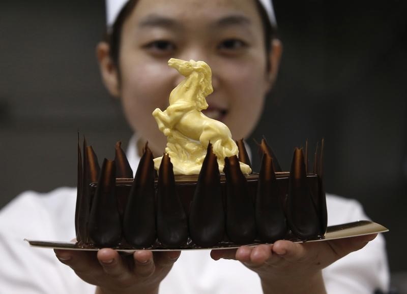 © Reuters. A chef shows a cake decorated with a white chocolate in the shape of a horse, during a photo opportunity at a kitchen of Kerry's Pantry, ahead of upcoming Chinese lunar New Year, in Beijing