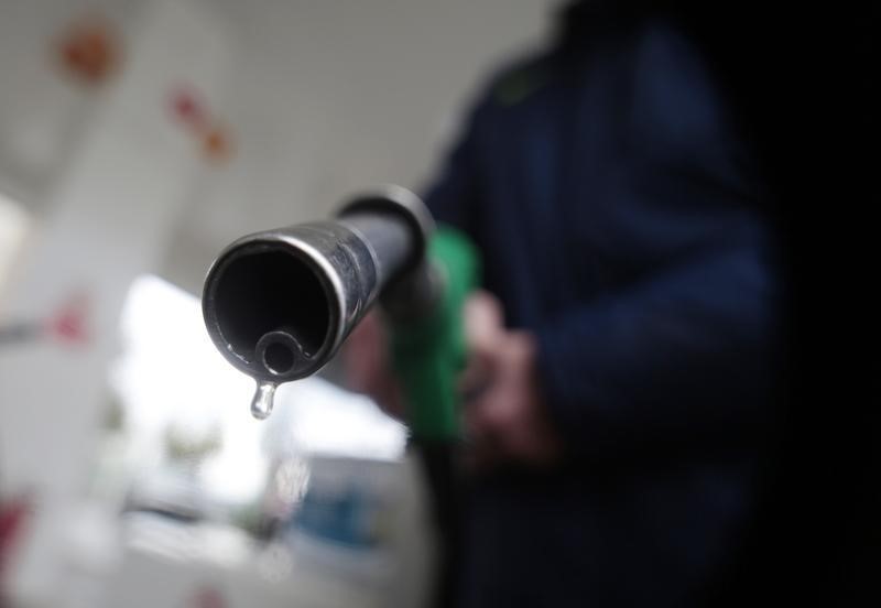 © Reuters. A customer holds a nozzle to fill up his tank in a gasoline station in Nice