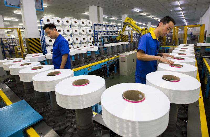 © Reuters. Employees work along a production line of a textile factory in Suzhou