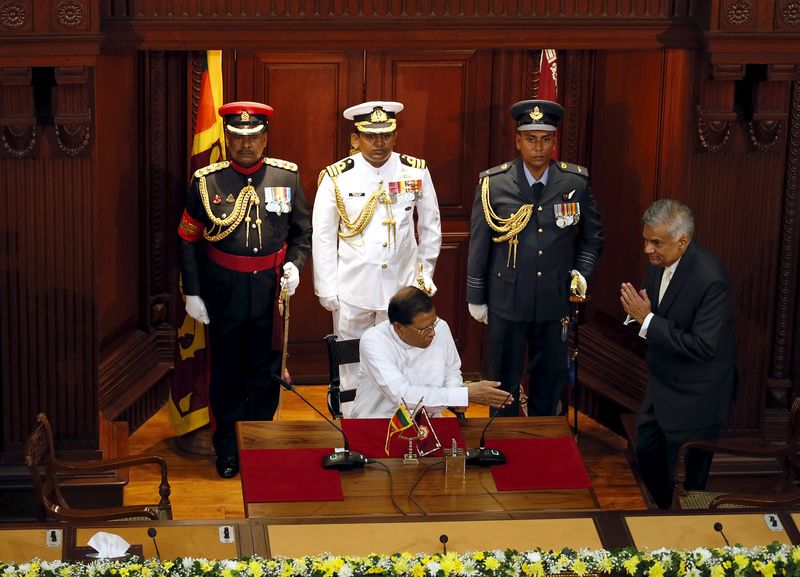 © Reuters. Wickremesinghe, leader of the United National Party, makes a gesture of greeting next to Sri Lanka's President Sirisena during a ceremony to swear him in as Sri Lanka's new prime minister in Colombo