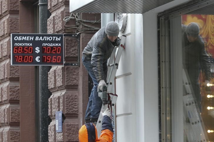 © Reuters. Рабочие у здания, в котором расположен пункт обмена валюты 