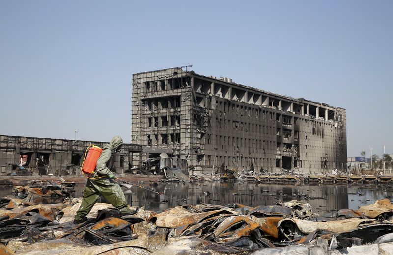 © Reuters. Militar limpando destroços em Tianjin, na China