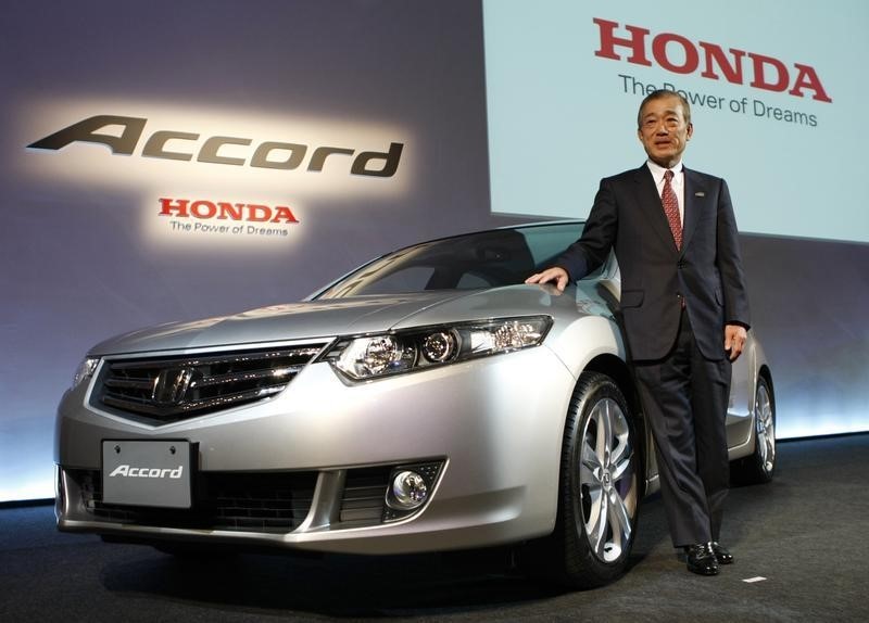 © Reuters. Honda Motor Co. President and CEO Fukui poses with the company's all-new Accord car during its unveiling in Tokyo