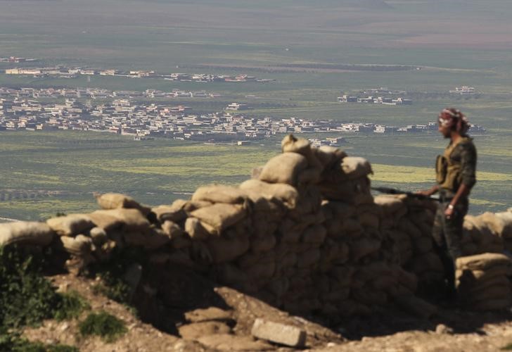 © Reuters. Membro das forças curdas peshmergas observa Mosul