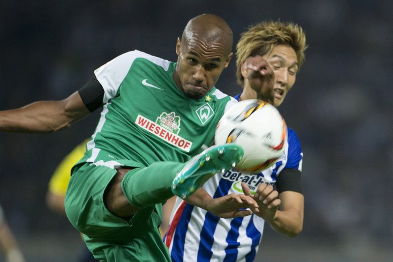 © Reuters.  Theodor Gebre Selassie fights for the ball with Genki Haraguchi during the German first division Bundesliga soccer match between Werder Bremen and Hertha BSC Berlin in Berlin