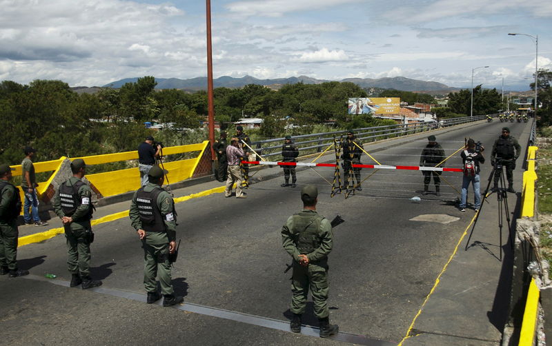 © Reuters. Venezuela's National Guards stand in front of Colombia's soldiers at Simon Bolivar international bridge, on the border with Colombia, at San Antonio in Tachira state