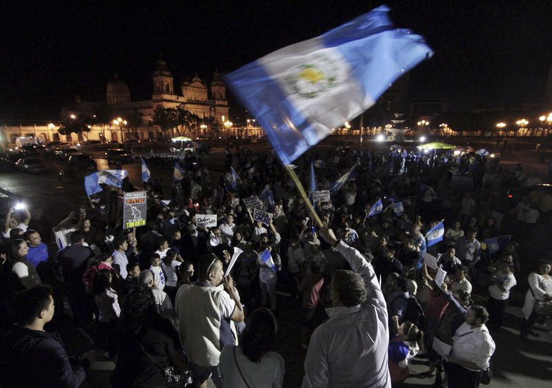 © Reuters. Demonstrator waves a Guatemalan national flag while gathering with others during a protest against Guatemala's President Otto Perez in Guatemala City, Guatemala