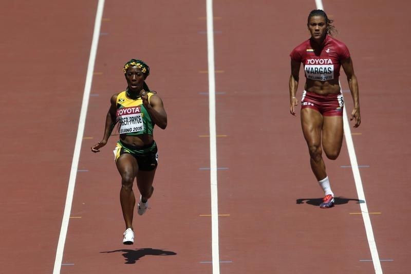 © Reuters. Fraser-Pryce sprints ahead of Vargas to win their women's 100 metres heat at the 15th IAAF World Championships at the National Stadium in Beijing