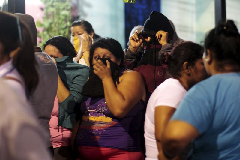 © Reuters. Relatives wait for news outside a prison where 14 members of the Barrio 18 group were killed in Quezaltepeque