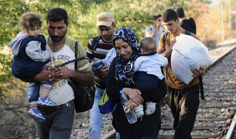 © Reuters. مهاجرون يعبرون من اليونان الى مقدونيا بلا عوائق