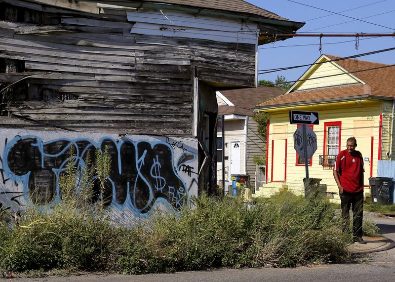 © Reuters. A man walks past an abandoned bulding in the Upper Ninth Ward neighborhood of New Orleans, Louisiana