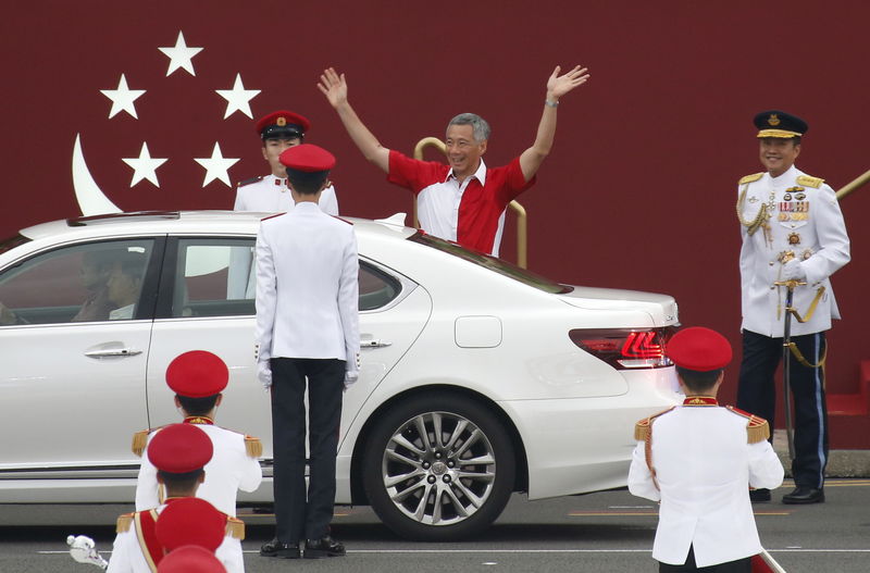 © Reuters. Singapore's Prime Minister Lee Hsien Loong waves as he arrives for Singapore's Golden Jubilee celebrations at the Padang near the central business district 