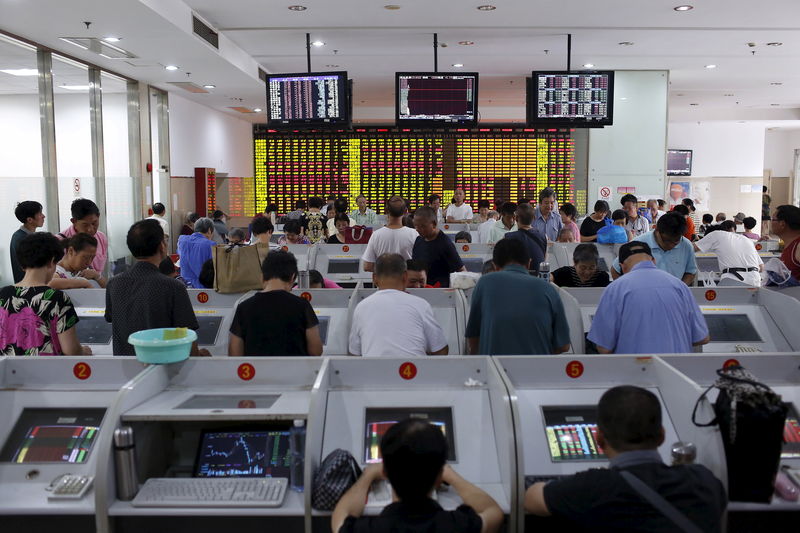 © Reuters. Investors look at computer screens showing stock information at a brokerage in Shanghai