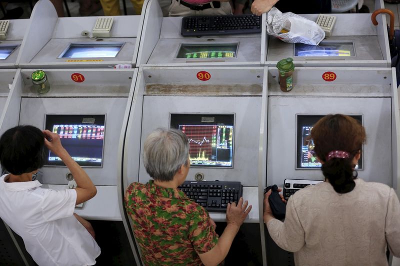 © Reuters. Investors look at computer screens showing stock information at brokerage in Shanghai
