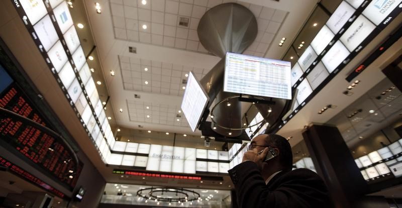 © Reuters. Homem no telefone enquanto olha monitores com cotações, em São Paulo