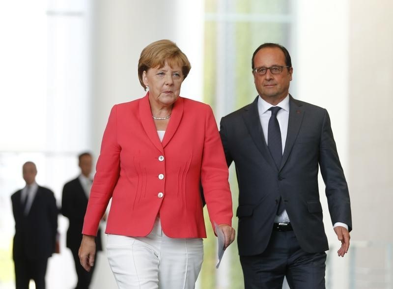 © Reuters. HOLLANDE ET MERKEL  PRÉVIENNENT QUE LA CRISE DES MIGRANTS VA DURER