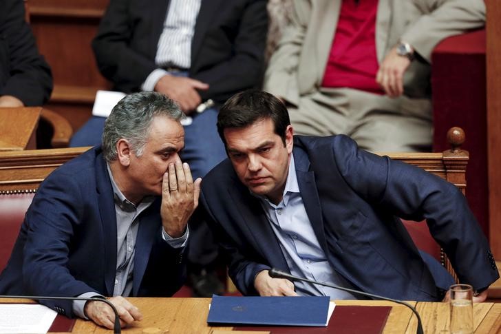 © Reuters.  Alexis Tsipras talks with Energy Minister Panos Skourletis during a parliamentary session in Athens, Greece