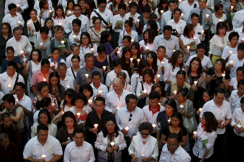 © Reuters. People light candles for victims during a march to the Erawan shrine, the site of last Monday's deadly blast, in Bangkok