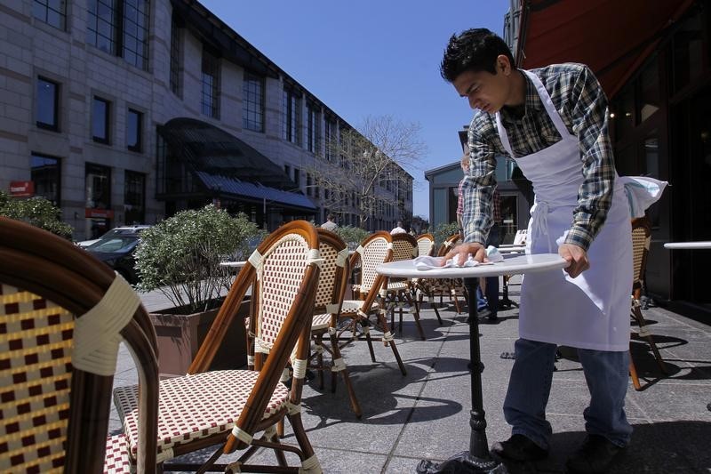 © Reuters. A waiter cleans off a table as life returns to Boylston Street after the Boston Marathon bombings in Boston, Massachusetts