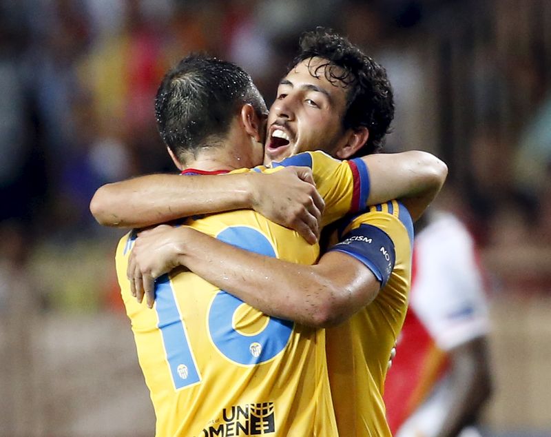 © Reuters. Daniel Parejo, do Valencia, abraça colega Javie Fuego após derrotar Monaco