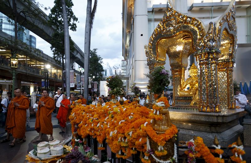 © Reuters. Buddhist monks pray for victims of last Monday's deadly blast, as they walk at the Erawan shrine in Bangkok