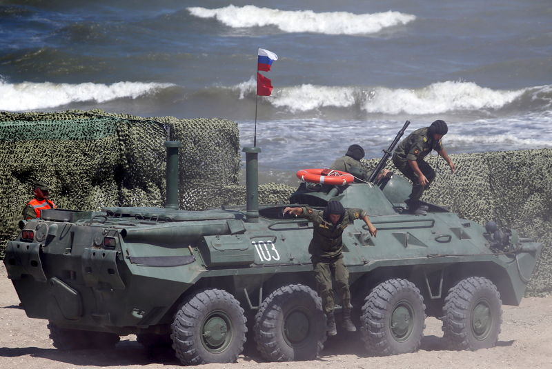 © Reuters. Russian navy servicemen leave armoured personnel carrier as they take part in Caspian Derby-2015 international naval contest in Kaspiysk