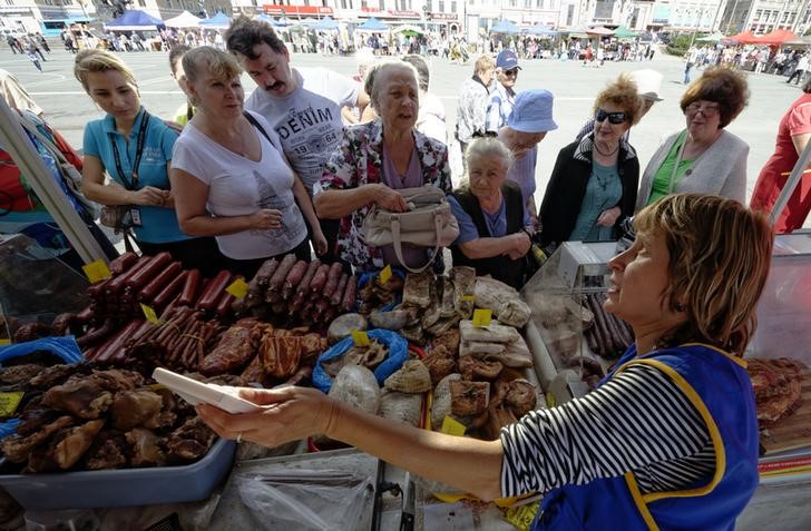 © Reuters. Женщина торгует мясными и колбасными изделиями на продуктовой ярмарке во Владивостоке 