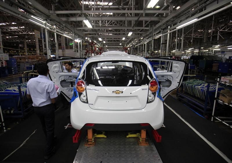 © Reuters. Employees work on a Chevrolet Beat car on an assembly line at the General Motors plant in Talegaon