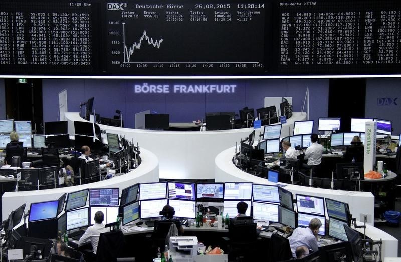 © Reuters. Traders are pictured at their desks in front of the DAX board at the Frankfurt stock exchange