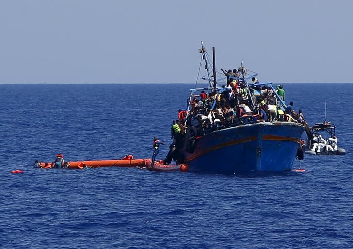 © Reuters. Imigrantes pulam na água na área da costa da Líbia