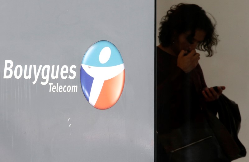 © Reuters. A man checks his mobile device at a French telecom operator Bouygues Telecom store in Paris