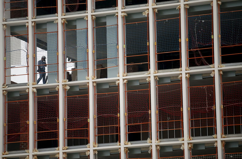 © Reuters. A worker talks by phone in a building under construction in Barcelona