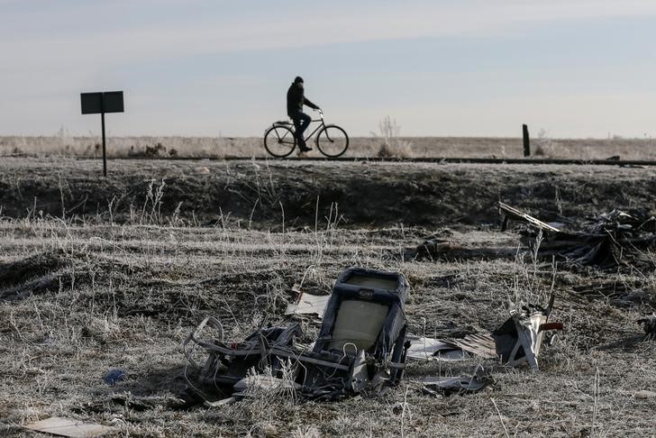 © Reuters. File photo of a man riding his bicycle past the wreckage of the Malaysia Airlines Flight MH17, near the village of Hrabove (Grabovo) in Donetsk region