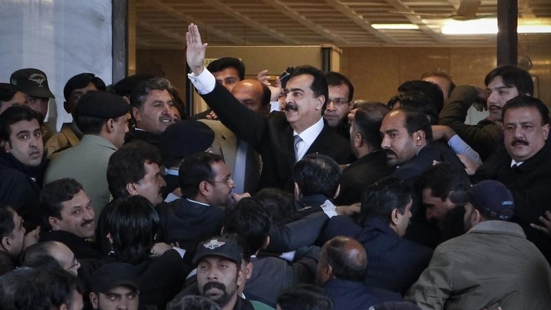 © Reuters. Pakistan Prime Minister Yusuf Raza Gilani waves after arriving to the Supreme Court in Islamabad