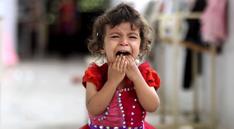 © Reuters. A girl cries as she walks onto the veranda at the yard of a school sheltering people displaced by Saudi-led air strikes on Yemen's northwestern province of Saada, in the capital Sanaa